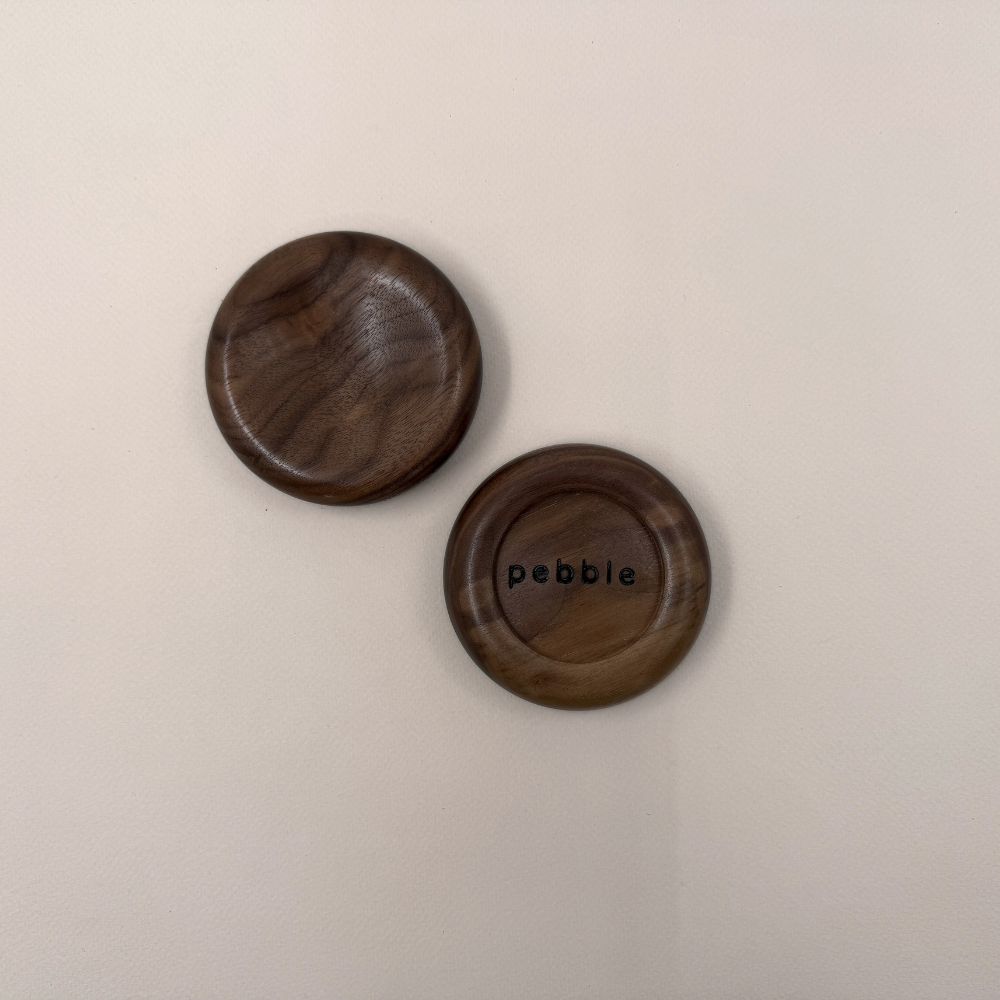 Two Onslow Salt Dish in Walnut. One facing upward and the other shows the bottom with "Pebble" branding