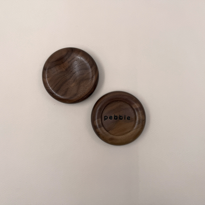 Two Onslow Salt Dish in Walnut. One facing upward and the other shows the bottom with "Pebble" branding