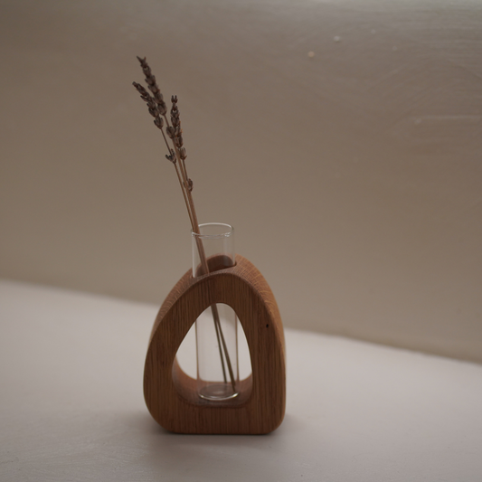 Wooden vase with a clear glass insert holding dried lavender on a neutral background