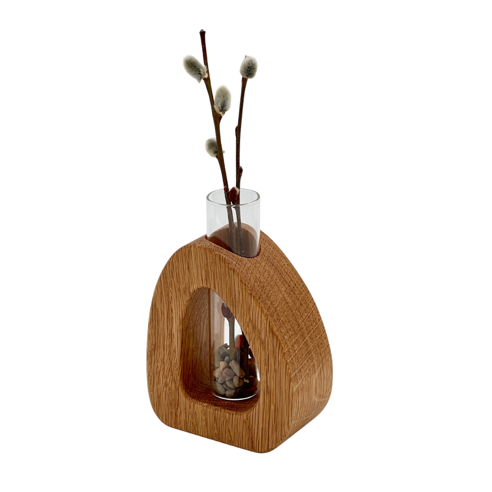 Wooden vase with glass insert holding willow branches on a white background