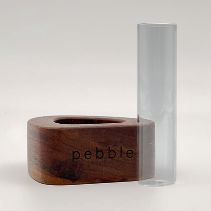 Wooden vase with 'pebble' branding next to a clear glass vase on a white background