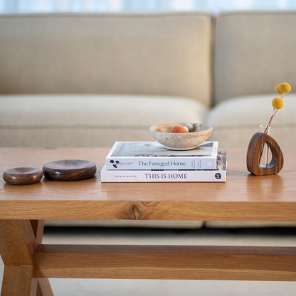 Wooden coffee table with books and decorative items in a living room setting
