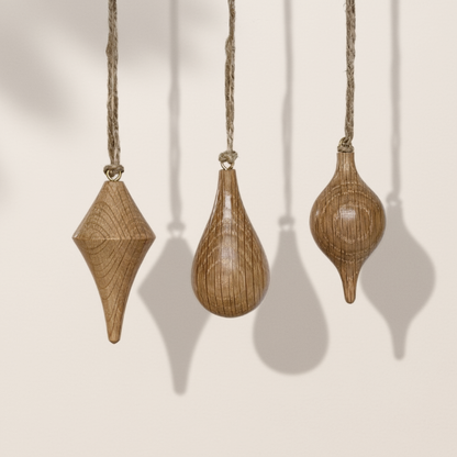 Minimalist icicle shapes in oak wood with jute string. Handcrafted Christmas ornaments by Pebble Studio