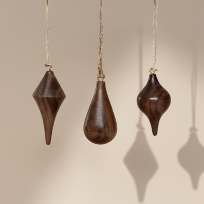 Hand turned walnut timber ornaments in organic icicle shapes with jute loop. Pebble Studio sustainable Christmas decor