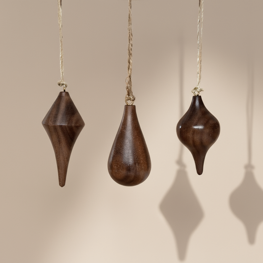 Hand turned walnut timber ornaments in organic icicle shapes with jute loop. Pebble Studio sustainable Christmas decor