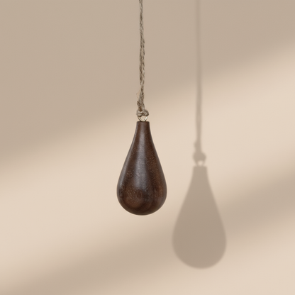 Hand turned walnut timber ornament in teardrop shape with jute loop. Pebble Studio sustainable Christmas decor