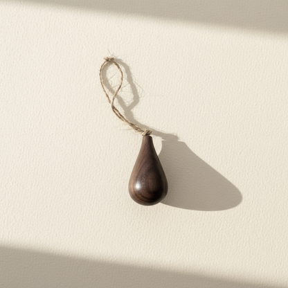 Hand turned walnut timber ornament in teardrop shape with jute loop. Pebble Studio sustainable Christmas decor