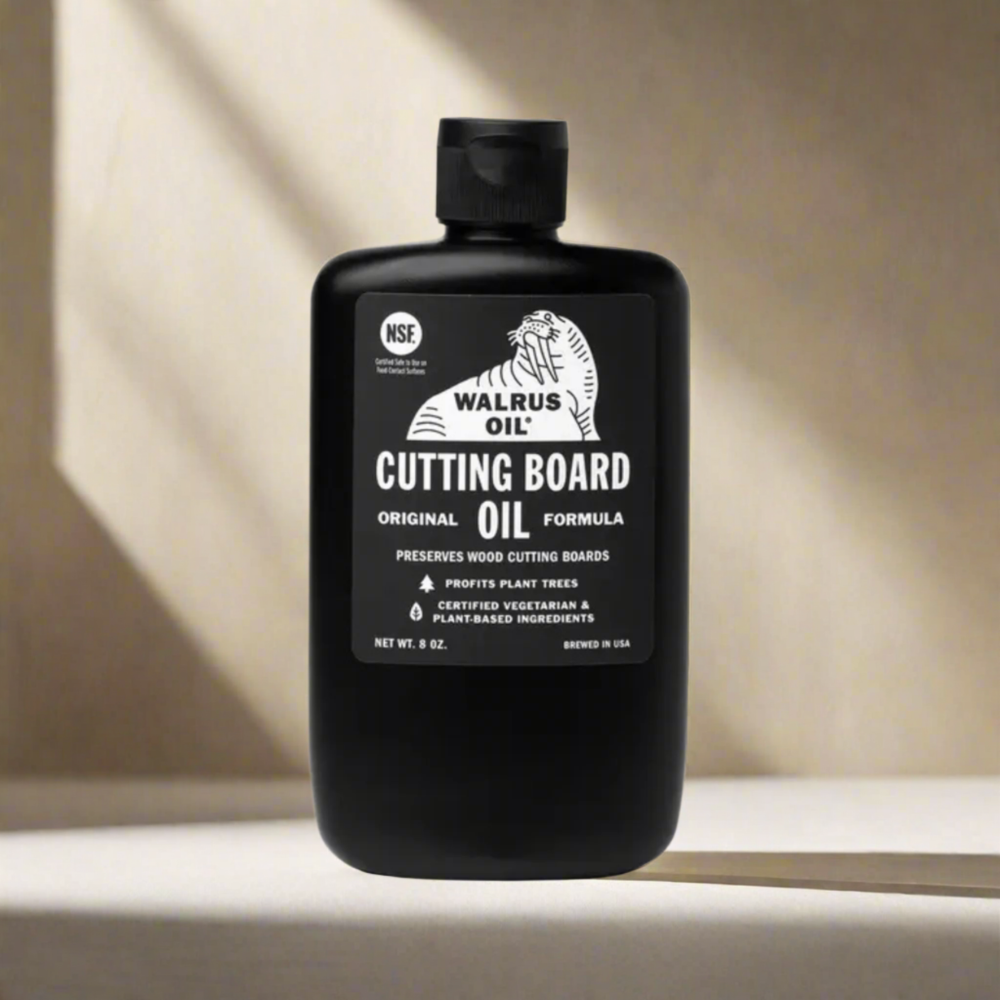 Black bottle of Walrus Oil Cutting Board Oil on a neutral background