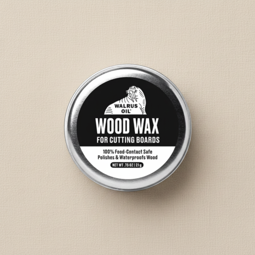 A round metal tin holding 21g of Walrus Oil Wood Wax for cutting boards, featuring a black and white label, set against a textured beige background.