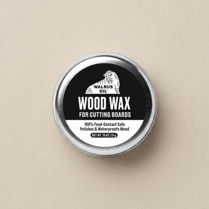 A round metal tin holding 21g of Walrus Oil Wood Wax for cutting boards, featuring a black and white label, set against a textured beige background.