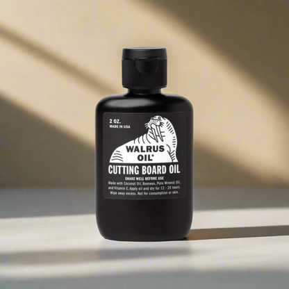 A black bottle of Walrus Chopping Board Oil with white and green label, indicating it is a food-contact safe wood finish conditioner.