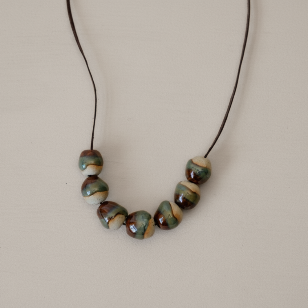 Necklace with ceramic beads on a beige background