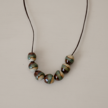 Necklace with ceramic beads on a beige background