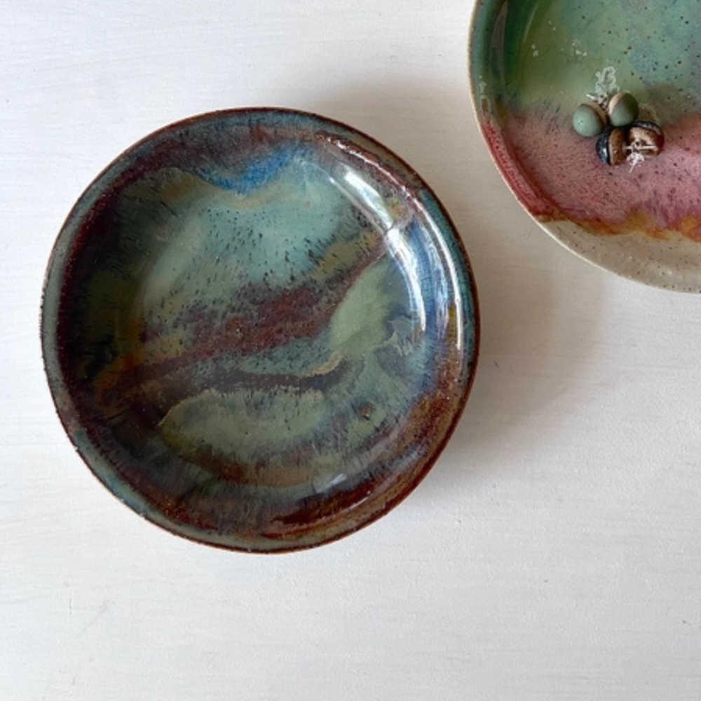 Two ceramic dishes with textured glazes on a white background