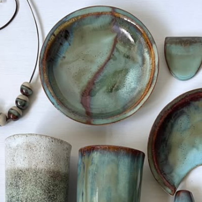 Collection of ceramic items with textured glazes on a white surface
