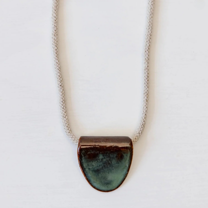 Necklace with a green ceramic pendant on a white background