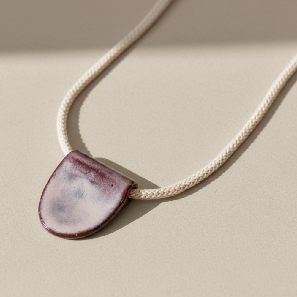 Necklace with a ceramic pendant on a beige background
