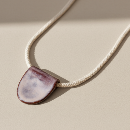 Necklace with a ceramic pendant on a beige background