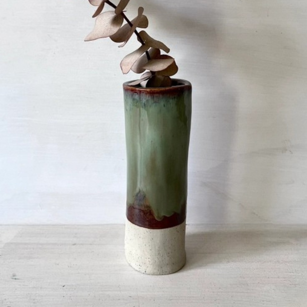 Cylindrical ceramic vase with a gradient finish on a plain background