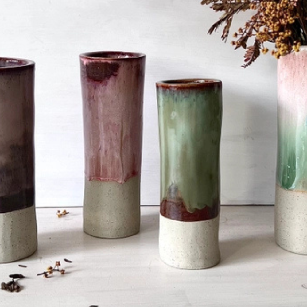 Four ceramic vases with gradient colours on a white surface.