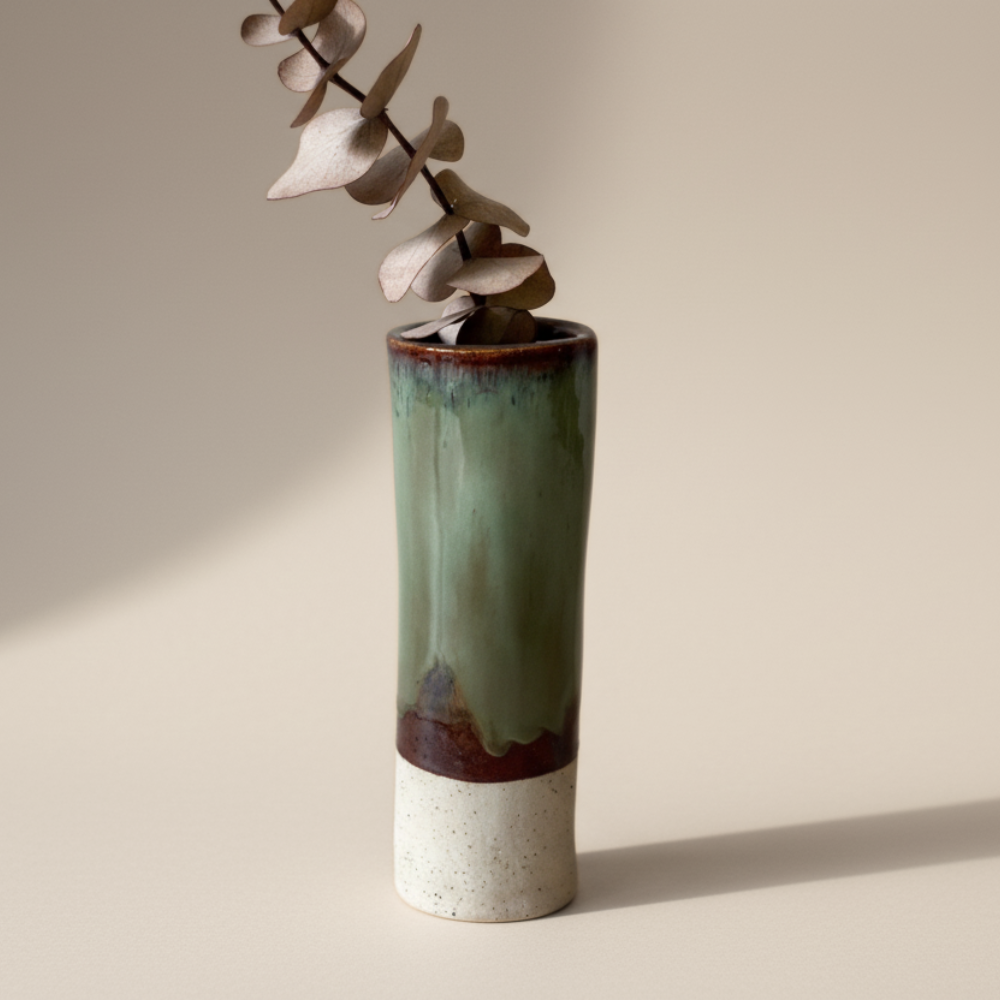 Green ceramic vase with a neutral base on a beige background