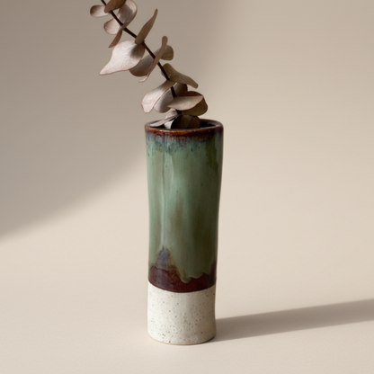 Green ceramic vase with a neutral base on a beige background