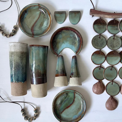 Collection of ceramic pieces with green and brown glaze on a white background