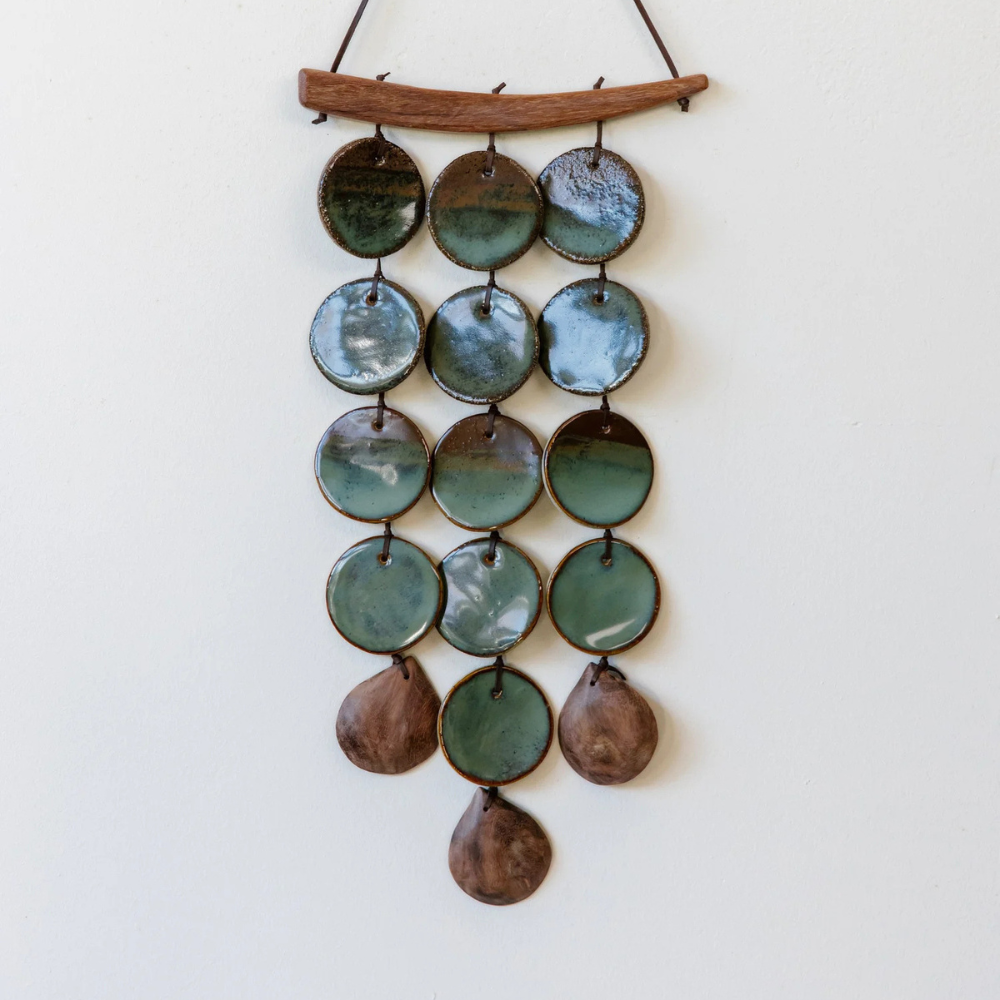 Decorative hanging with green and brown circular elements on a white background