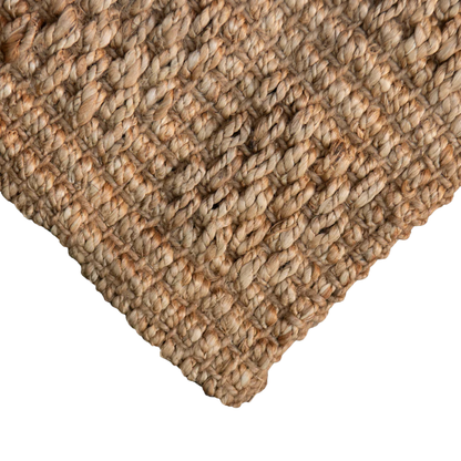 Close-up of a textured jute woven doormat on a white background