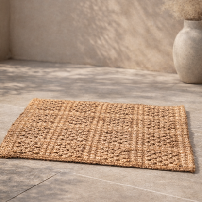 Woven doormat on a tiled floor with a neutral background