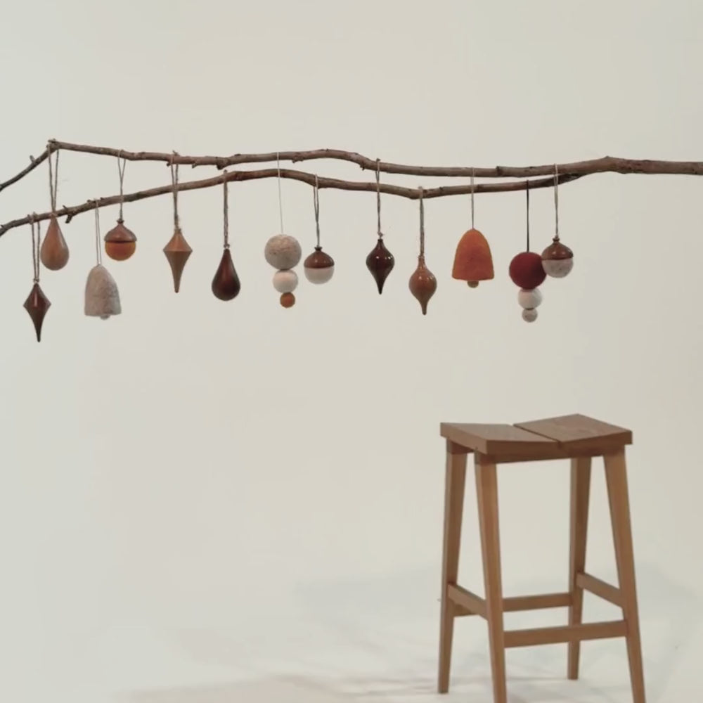Handmade Christmas ornaments on a branch, for slow holiday styling