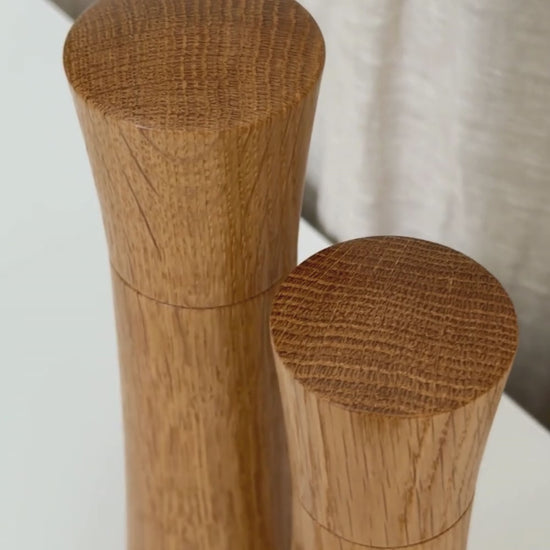 Medium and Large Pebble Studio Salt & Pepper Mill in American Oak. Minimalist design on a neutral background